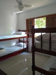 a bedroom with two bunk beds and a window at Vivenda Cravo&Canela in Abraão
