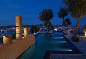 a swimming pool at night with trees and lights at Hotel La Torre del Canonigo - Small Luxury Hotels in Ibiza Town