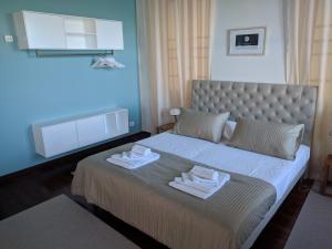 ein Schlafzimmer mit einem Bett mit zwei Handtüchern darauf in der Unterkunft Pep's Rooms by the sea in Triest