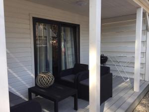 a porch with two chairs and a table on a house at Villa Playa in Dziwnówek +3 photos