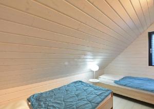 ジブヌベクにあるVilla Playaの木製の壁のドミトリールームのベッド1台分です。