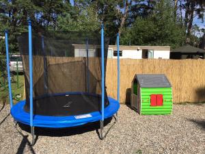 a trampoline in a yard with a dog house at Villa Playa in Dziwnówek