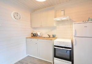 ジブヌベクにあるVilla Playaの白い冷蔵庫付きのキッチン、壁掛け時計