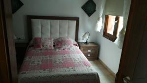 1 dormitorio con 1 cama con manta rosa y espejo en Paraiso Rubicón en Tías
