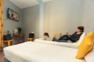 a woman and a child sitting on beds in a room at Arty Paris Porte de Versailles by River in Paris