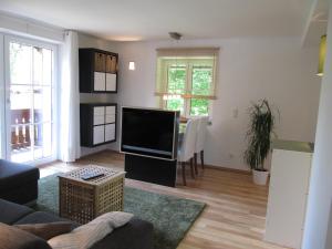 a living room with a flat screen tv and a table at gartenhouse in St. Wolfgang