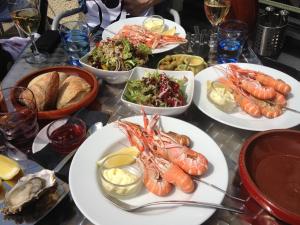 a table topped with plates of seafood and other foods at The Old Stables, Alltshellach Cottages in North Ballachulish
