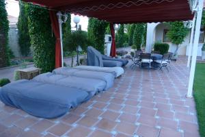 un patio con almohadas azules bajo una pérgola en Villamercedes II en Villamayor