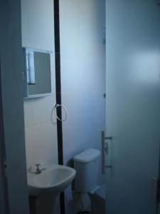 La salle de bains est pourvue de toilettes blanches et d'un lavabo. dans l'établissement Pousada do Ze Louquinho, à Aparecida