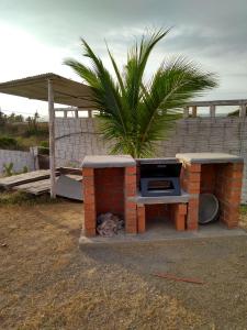 a brick oven with a dog sleeping under it at Bonanza Beach House Zorritos in Bocapán