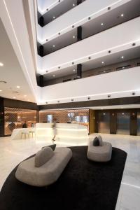 a lobby with two ottoman seating in a building at Negresco Princess 4* Sup in Barcelona