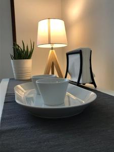 two bowls on a plate on a table with a lamp at Pep's Rooms by the sea in Trieste