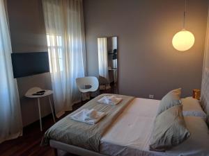 a bedroom with a bed with two towels on it at Pep's Rooms by the sea in Trieste