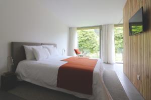 - une chambre avec un grand lit et une grande fenêtre dans l'établissement World's Nests Furnas Pods Village, à Furnas