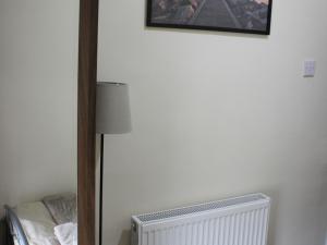 a bedroom with a radiator and a picture on the wall at Mary House 46 in Porthcawl