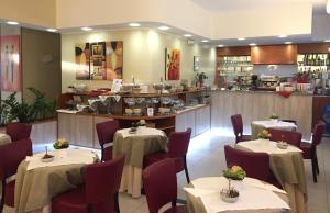 a restaurant with tables and chairs and a counter at Hotel Arcobaleno in Vimodrone