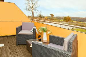 a balcony with two chairs and a table on a roof at Hotel Bergmühle in Bansin