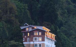 un edificio con luces en el lateral de una montaña en Summit Hermon Hotel & Spa, en Darjeeling