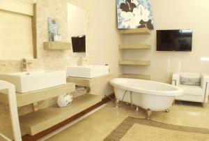 a bathroom with a tub and a sink and a mirror at Point Village Accommodation - Santos 61/62 in Mossel Bay +25 photos