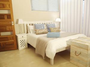 a bedroom with two beds with blue and white pillows at Point Village Accommodation - Santos 61/62 in Mossel Bay