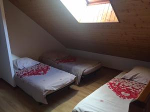 a attic room with two beds and a window at Résidence Les Ecrins in Ancelle