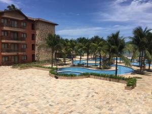 ośrodek z 2 basenami i palmami w obiekcie Residence Kariri Beach Cumbuco w mieście Cumbuco