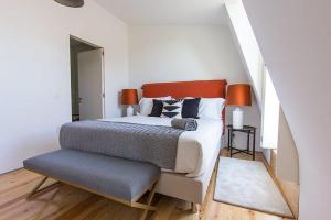 a bedroom with a bed with an orange headboard at Luxury T.M. Penthouse With a View in Lisbon
