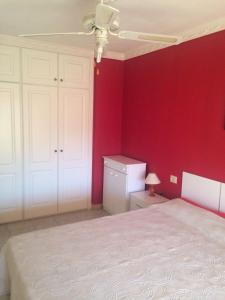 プエルト・デ・サンティアゴにあるResidencial Jardines Del Marの赤い壁のベッドルーム1室(ベッド1台付)