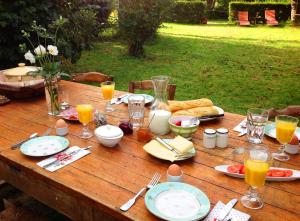 a wooden table with food and drinks on it at Domaine Charente - Holiday Home with own garden in Mazières