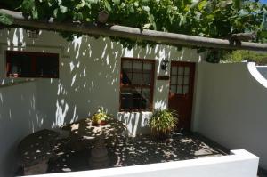 a house with two potted plants in front of it at Long Acres Cottages in Montagu