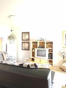 a living room with a couch and a tv at Point Village Accommodation - Estoril 26 in Mossel Bay