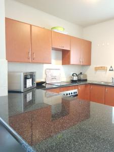 a kitchen with a counter top and a microwave at Point Village Accommodation - Estoril 26 in Mossel Bay