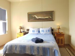 um quarto com uma cama com toalhas azuis em Point Village Accommodation - Estoril 26 em Mossel Bay