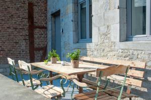 a wooden table and chairs in front of a building at Le Coeur de Durbuy in Durbuy