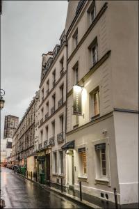 巴黎的住宿－蒙特貝洛公寓式酒店，一条雨林密布的街道上一排建筑物