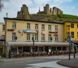 a building with tables and chairs on a street at Hotel Restaurant La Piazza in Valkenburg