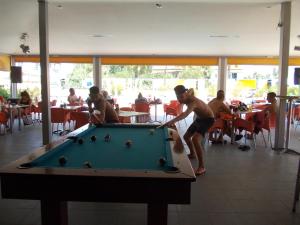 two men playing a game of pool in a restaurant at Kavos Central Gardens in Kavos