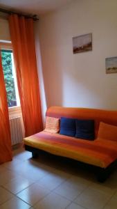 サンレモにあるMarina Bluのオレンジ色のカーテンが付いた客室内の木製ベンチ