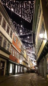 a street with christmas lights hanging from a building at Zum kleinen Riesen in Erfurt