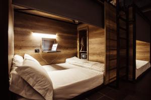 een slaapkamer met 2 stapelbedden en een laptop aan de muur bij Eco Hostel in Catania