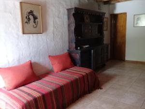 a room with a couch with two red pillows at El Alto de las Paredes in San Rafael