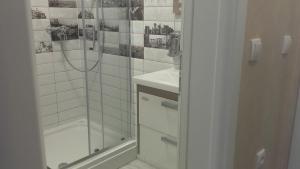 a white bathroom with a shower and a sink at Guesthouse Nikolić in Negotin