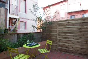 d'une terrasse avec une table, des chaises et une clôture. dans l'établissement L'Esquile by Cocoonr, à Toulouse