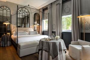 伦敦The Franklin London - Starhotels Collezione的一间卧室，里面有一张床、一张桌子和一把椅子