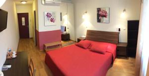 ein Schlafzimmer mit einem roten Bett in einem Zimmer in der Unterkunft LOGIS Hôtel Le Chantoiseau in Chaumont-sur-Aire