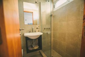 a bathroom with a sink and a shower at lacasonavistalago in Villa Carlos Paz +56 photos