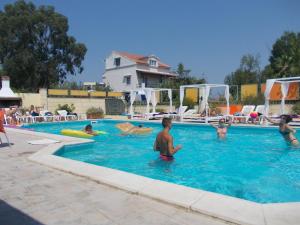 a group of people playing in a swimming pool at Kavos Central Gardens in Kavos +37 photos