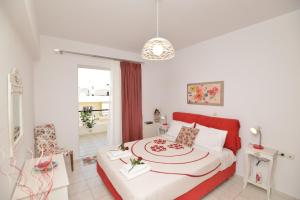 レティムノ・タウンにあるDiogenis Suiteのベッドルーム1室(赤いヘッドボード付きの大型ベッド1台付)