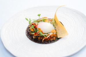 a plate of food with an egg and a tortilla at Europe Villa Cortes GL in Playa de las Americas