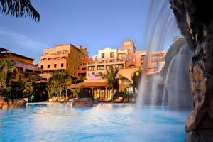 a fountain in the middle of a pool with buildings at Europe Villa Cortes GL in Playa de las Americas